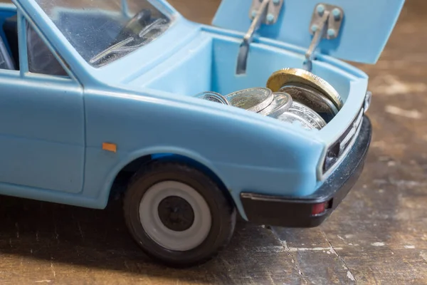 Money in the trunk of a children\'s toy car. Rise in the cost of fuel due to the war in Ukraine
