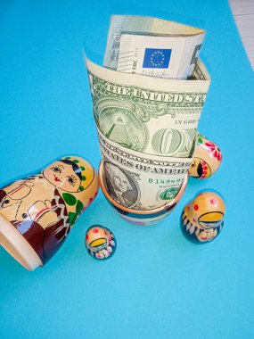 Para ve banknotlar bir domuz kumbarasının yanında, matryoshka şeklinde.