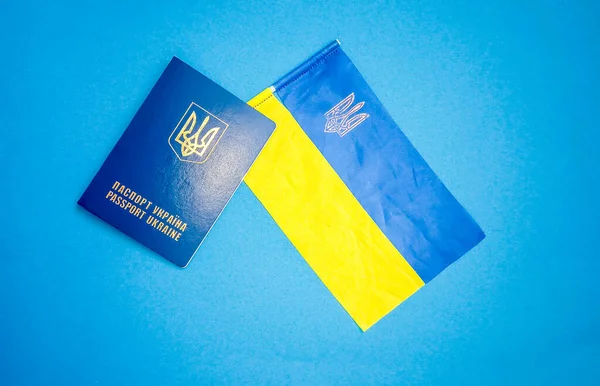Ukrainian passport and Ukrainian flag on a blue background