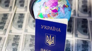 Ukrainian passport on banknotes near the globe. Departure of refugees due to the war in Ukraine