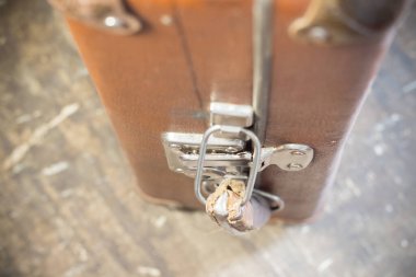 Üzerinde metal kilitler olan eski kahverengi bavul.