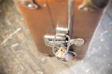 Üzerinde metal kilitler olan eski kahverengi bavul.