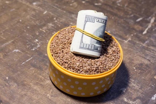 Banknotes in a bowl with buckwheat. The rise in food prices in Ukraine due to the war