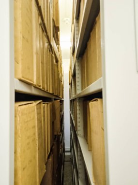 Ancient books in cardboard boxes on shelves in a museum in Slovakia