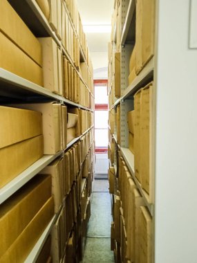 Ancient books in cardboard boxes on shelves in a museum in Slovakia