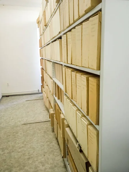 Ancient books in cardboard boxes on shelves in a museum in Slovakia