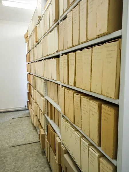 Ancient books in cardboard boxes on shelves in a museum in Slovakia