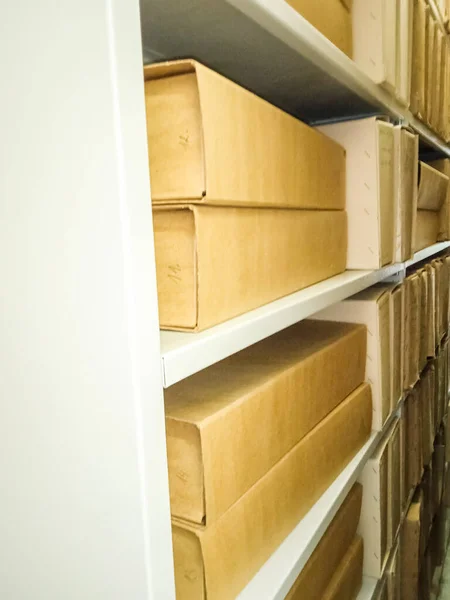 Ancient books in cardboard boxes on shelves in a museum in Slovakia