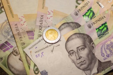 Italy 500 lire coin coins among 200 hryvnia banknotes. Inflation in Ukraine due to the war
