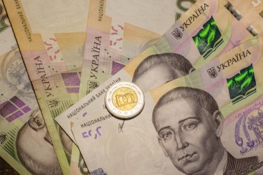 100 forint coin among 500 hryvnia banknotes. Inflation in Ukraine due to the war