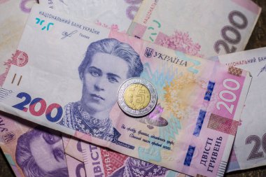 5 dollar coin among 200 hryvnia bills. Inflation in Ukraine due to the war