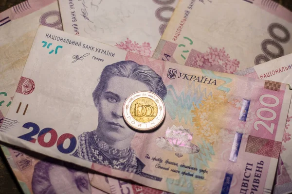 100 forint coin among 200 hryvnia banknotes. Inflation in Ukraine due to the war