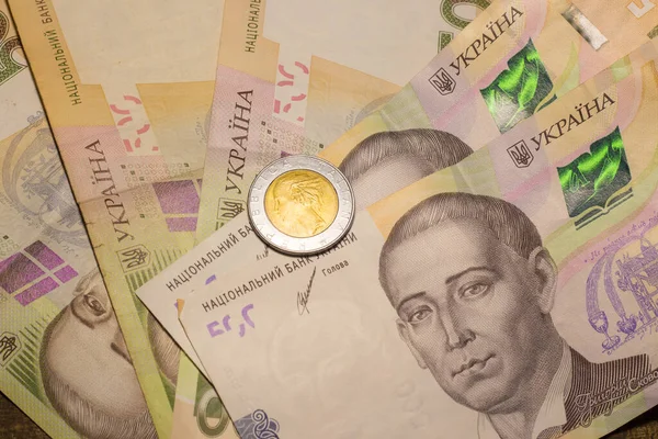 Italy 500 lire coin coins among 200 hryvnia banknotes. Inflation in Ukraine due to the war