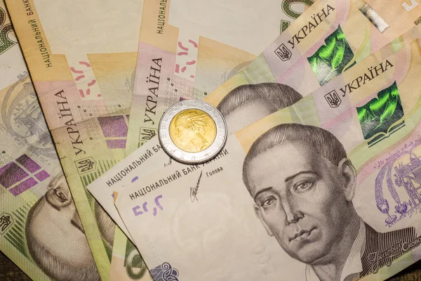 Italy 500 lire coin coins among 200 hryvnia banknotes. Inflation in Ukraine due to the war