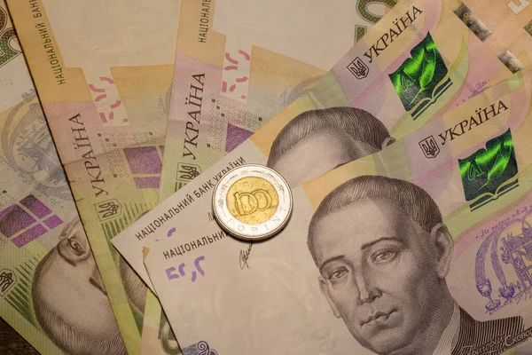 100 forint coin among 500 hryvnia banknotes. Inflation in Ukraine due to the war