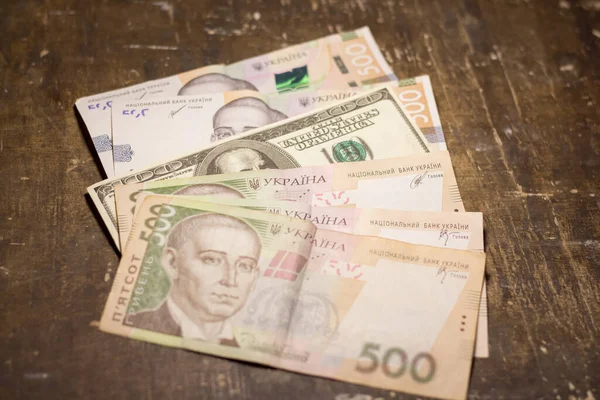 100 dollar bill among 500 hryvnia bills. Inflation in Ukraine due to the war