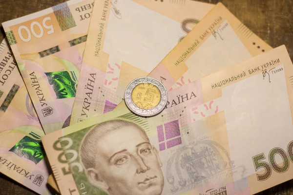 5 dollar coin among 500 hryvnia bills. Inflation in Ukraine due to the war