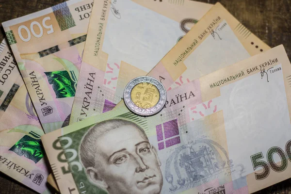 5 dollar coin among 500 hryvnia bills. Inflation in Ukraine due to the war