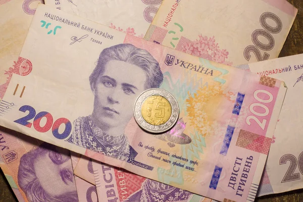 5 dollar coin among 200 hryvnia bills. Inflation in Ukraine due to the war