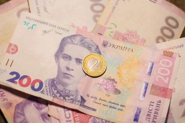 2 zloty coins among 500 hryvnia banknotes. Inflation in Ukraine due to the war