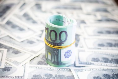 Euro bills on a roll on dollar bills. Inflation in Ukraine due to war