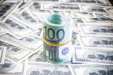 Euro bills on a roll on dollar bills. Inflation in Ukraine due to war