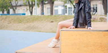 Kız parkta dinleniyor, ağaçların arasında.