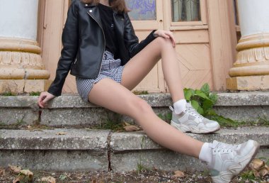 Eski binanın sütunlarının yanındaki kız.