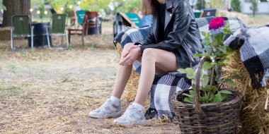 Kız parkta dinleniyor, ağaçların arasında.