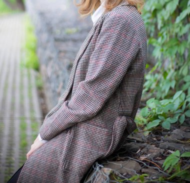 Kız sonbaharda parkta dinleniyor.