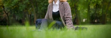 Sonbaharda çimlerin üzerinde dinlenen bir kız.