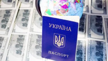 Ukrainian passport on banknotes near the globe. Departure of refugees due to the war in Ukraine