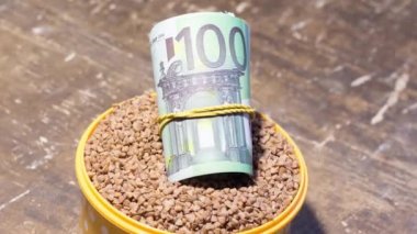 Karabuğdaylı bir kasede banknotlar. Savaş nedeniyle Ukrayna 'da gıda fiyatlarındaki artış