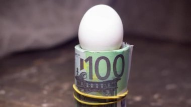 Banknotların arka planında tavuk yumurtası. Ukrayna 'daki savaş nedeniyle artan fiyatlar