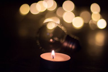 Ampul arka planında mum. Ukrayna 'da savaş nedeniyle elektrik kesintisi