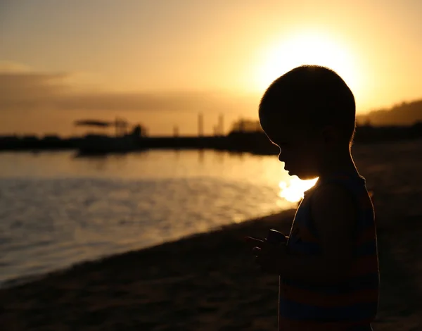 Kleine Junge Silhouette am Strand Stockbild