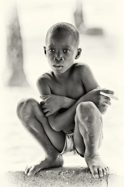 ガーナの少年は、地面に座ってください。 — ストック写真