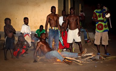 togo bir adamdan ateşin üzerinde oturur ve diğer adam ona bak