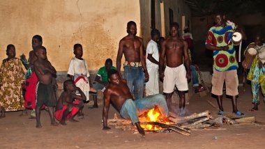 togo bir adamdan ateşin üzerinde oturur