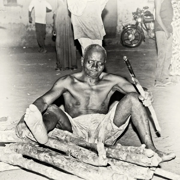 Un hombre de Togo se sienta en el ramo de madera —  Fotos de Stock