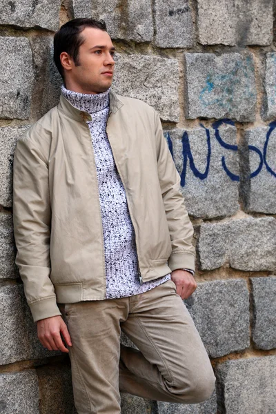 Young male model near the stone wall