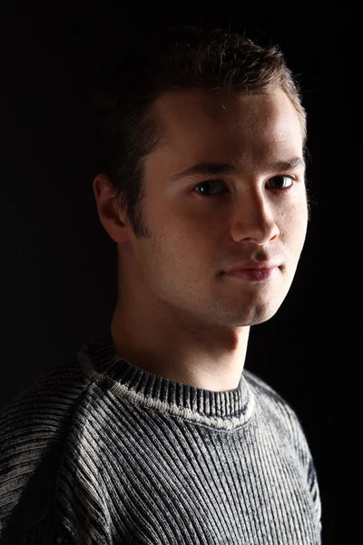 Um retrato de jovem modelo masculino isolado em preto — Fotografia de Stock