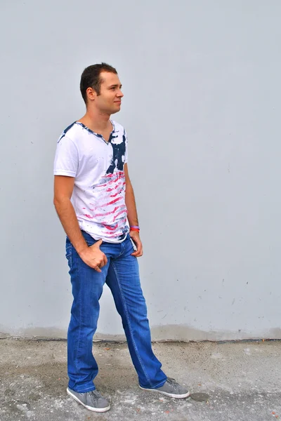 Posando de un joven modelo masculino sobre el gris — Foto de Stock