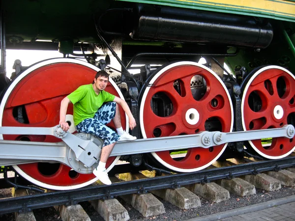 Niño posa sobre las ruedas del tren — Foto de Stock