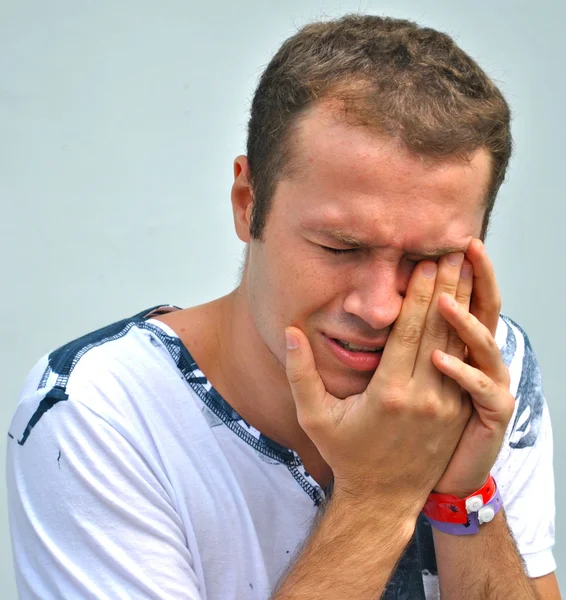 Jonge man raakt zijn oog omdat het pijn doet — Stockfoto