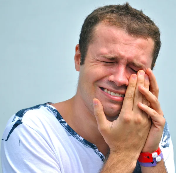 Joven toca su ojo porque duele —  Fotos de Stock