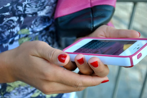 Chica enviar sms mensaje utilizando su blanco y rosa iPhone 4S —  Fotos de Stock