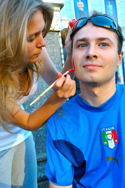 Fan of Italian football team prepares for the game painting the national flags on the cheeks during EURO 2012 — Stock Photo, Image