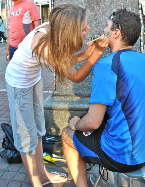 Fã do time de futebol italiano se prepara para o jogo pintando as bandeiras nacionais nas bochechas durante o EURO 2012 — Fotografia de Stock