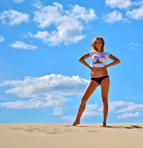 Mooie sexy model in shirt ans slipje vormt op het zand en de hemel — Stockfoto